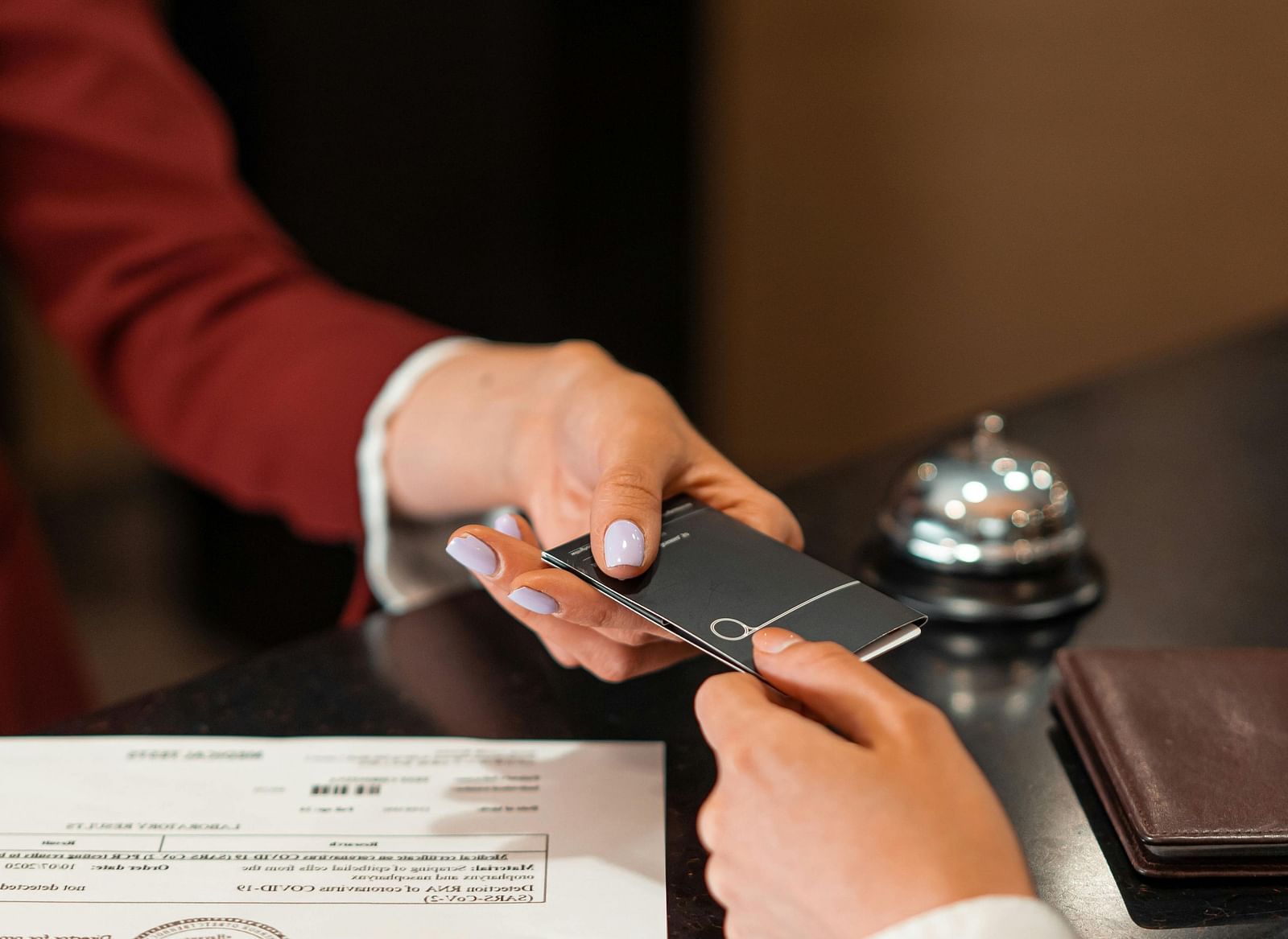 two people exchanging a room card on the front desk