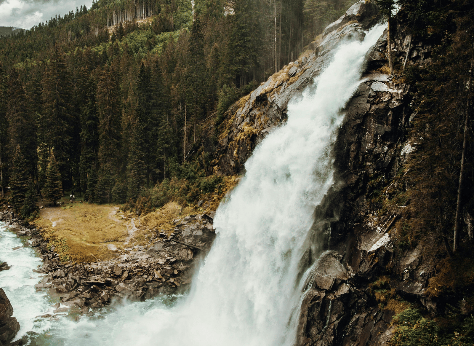 A large waterfall cascades down a rocky cliff.