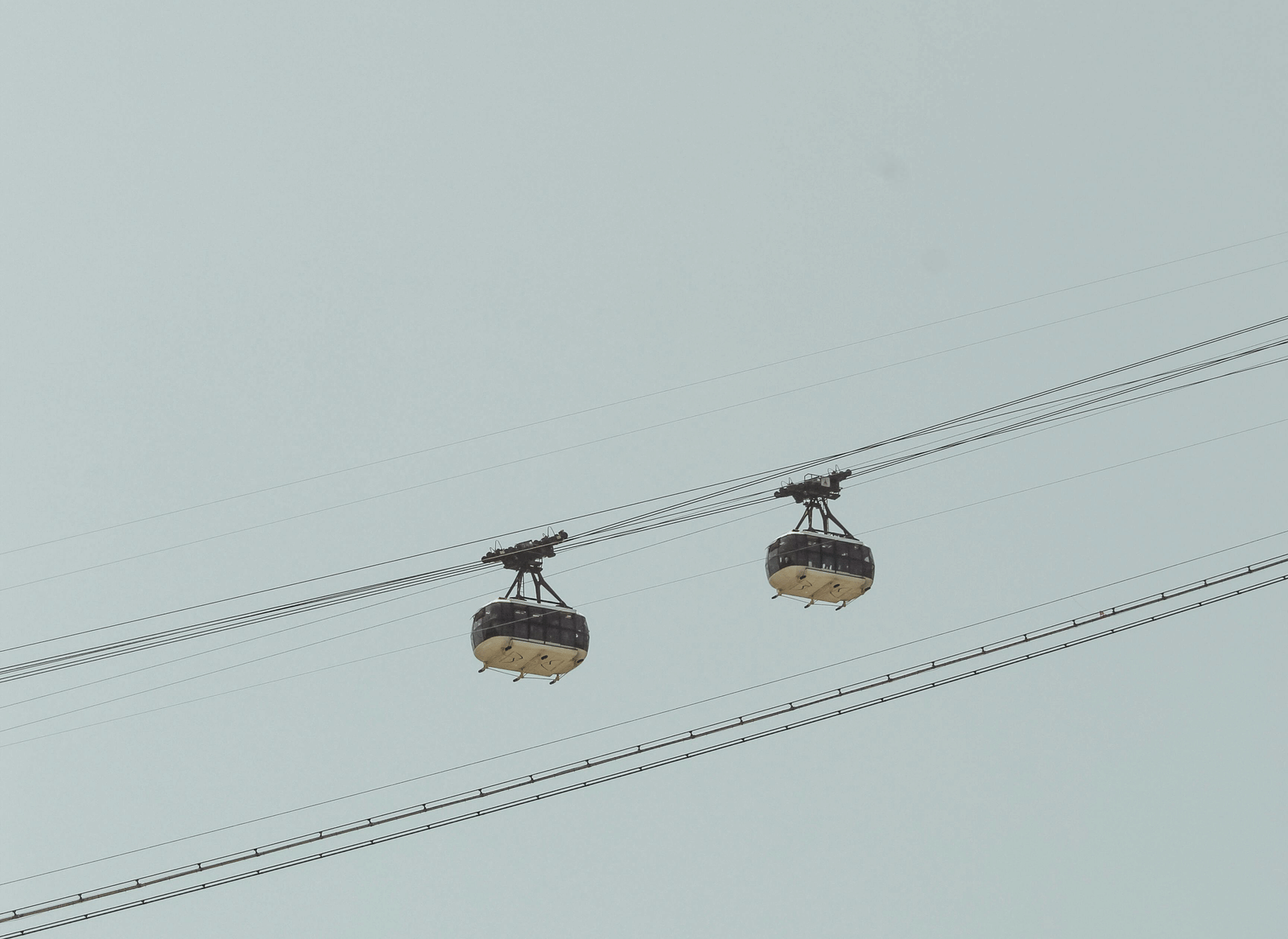 Exterior view of cable cars against a light sky.