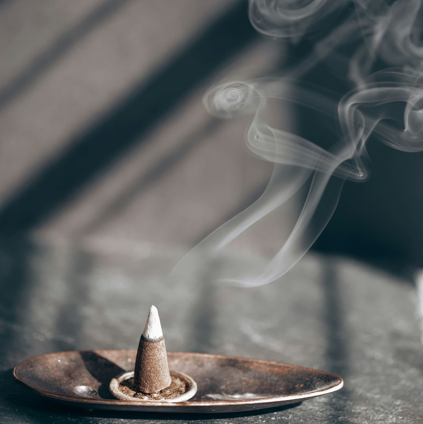 smoke rising from a lit incense cone 
