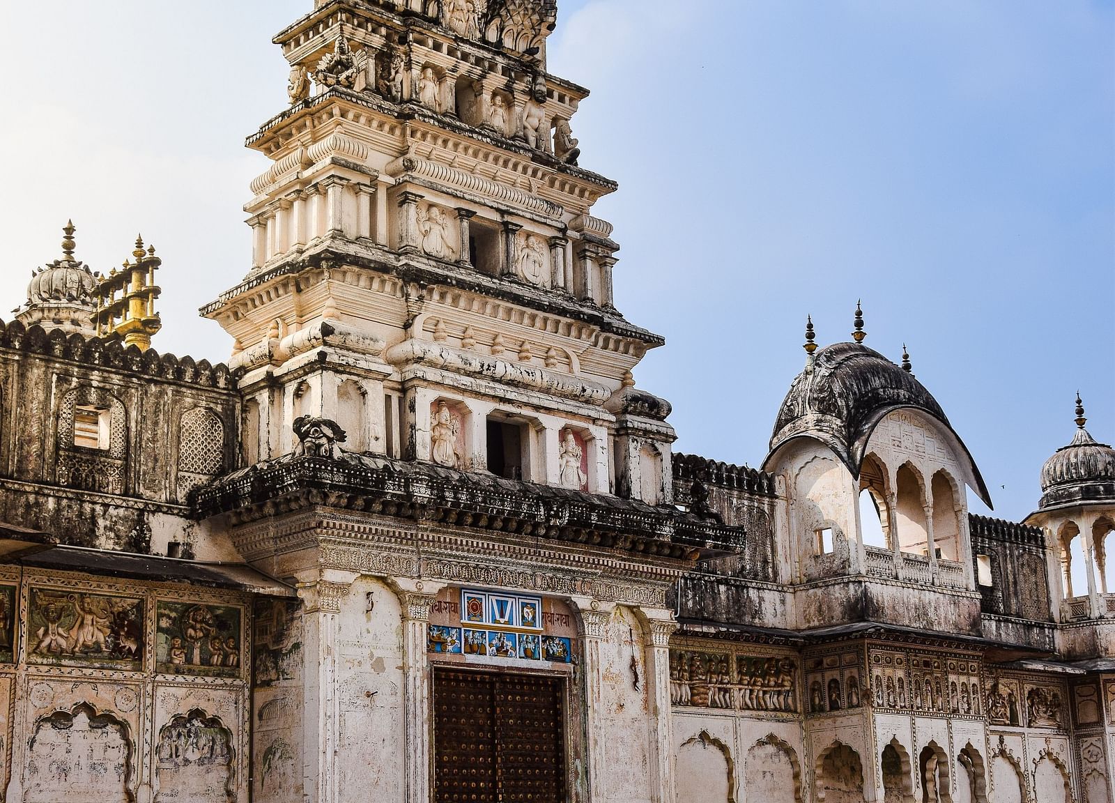 A tall, ornate temple or palace building with a white facade and intricate architectural details.