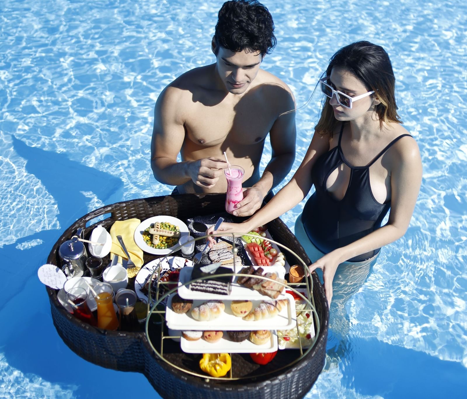 A couple enjoying a floating breakfast in a swimming pool - Polo Resort Cherrapunjee