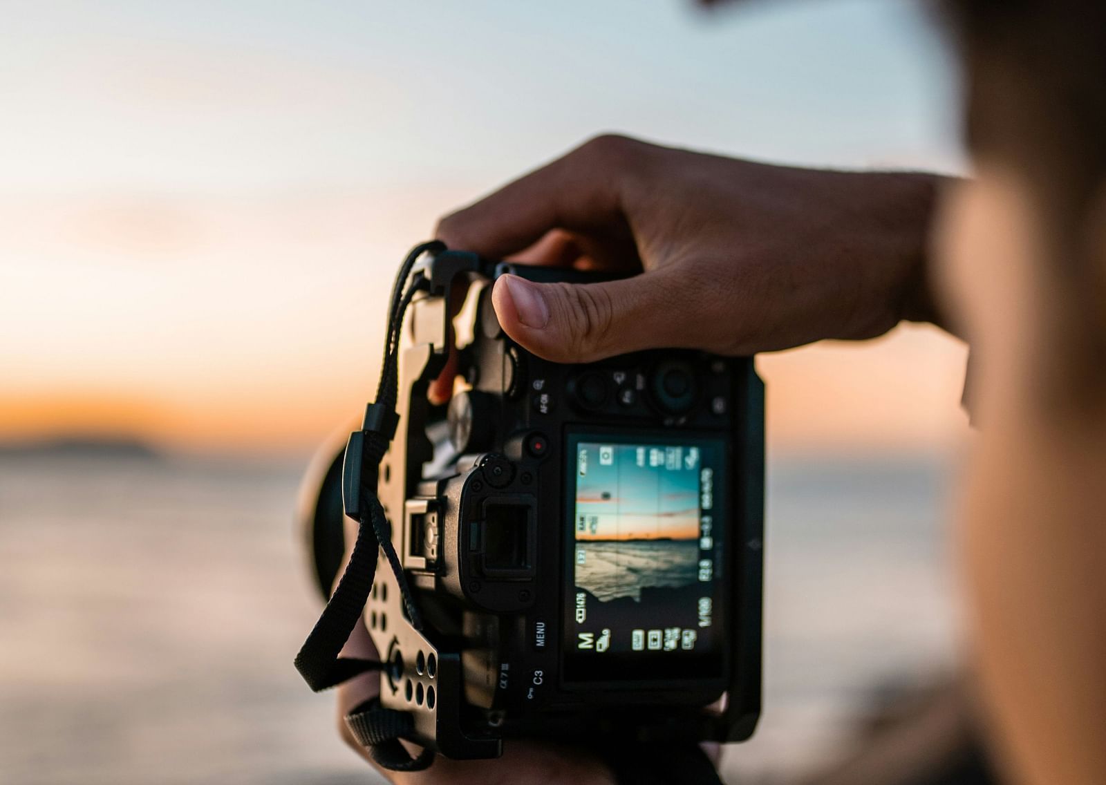 A close up shot of a camera of a person taking a picture of a mist covered land.