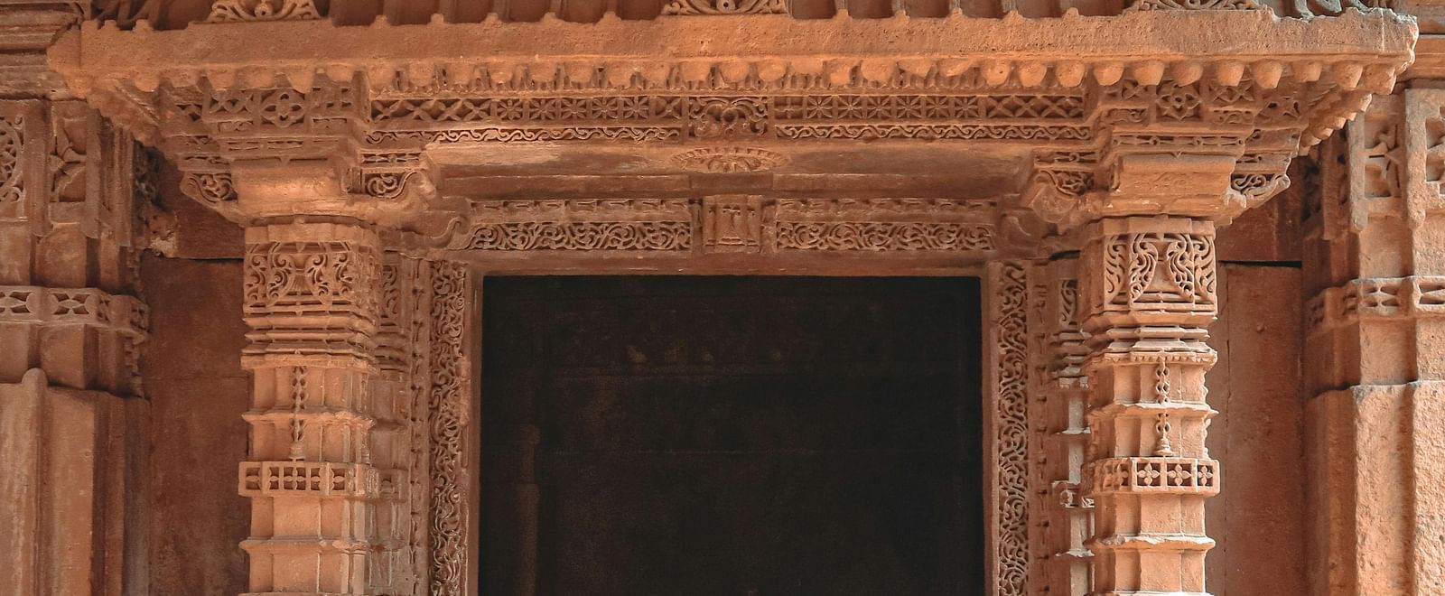 An ancient balcony with ornate stone carvings in a classical Indian architectural style