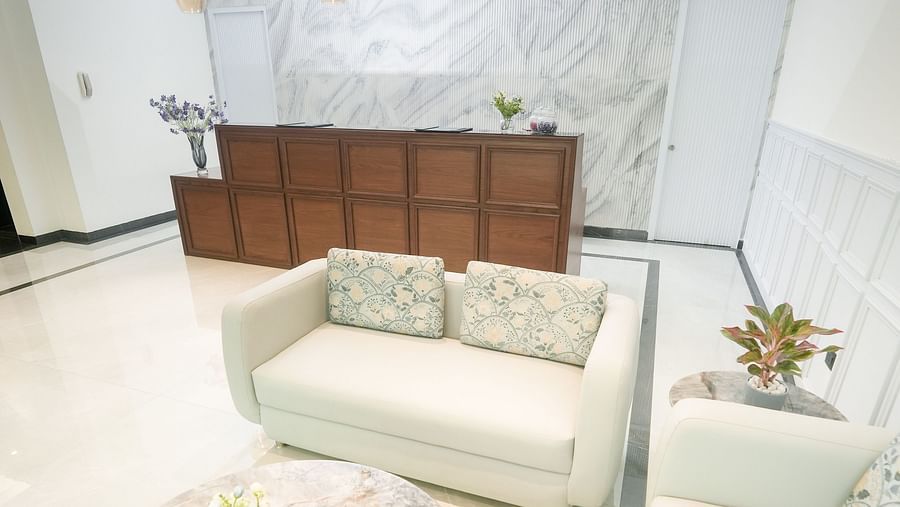 An image of a lobby with a large white sofa and a coffee table placed in front of a coffee table - NAMAMI BY ZENQ BANKHANDI