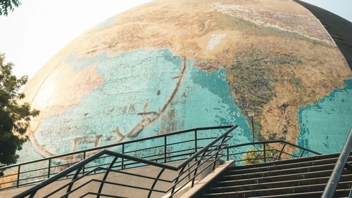The image shows stairs leading up to a platform in front of the globe.