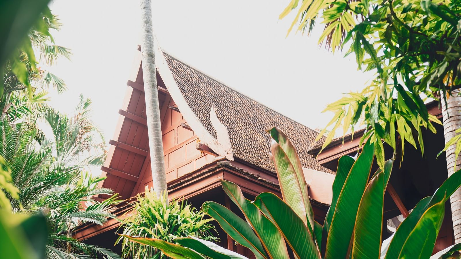 A view from the grass of Jim Thompson House Museum in the distance during the day.
