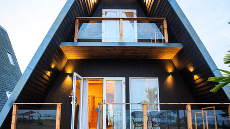 Daytime exterior view of a Duplex villa with balcony and surrounding greenery at Hotel Sonar Bangla, Taki.