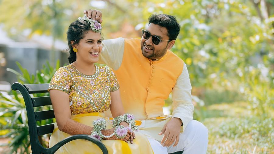 image of the bride and groom sitting together at a bench in the garden at darza resorts - coimbatore luxury resort