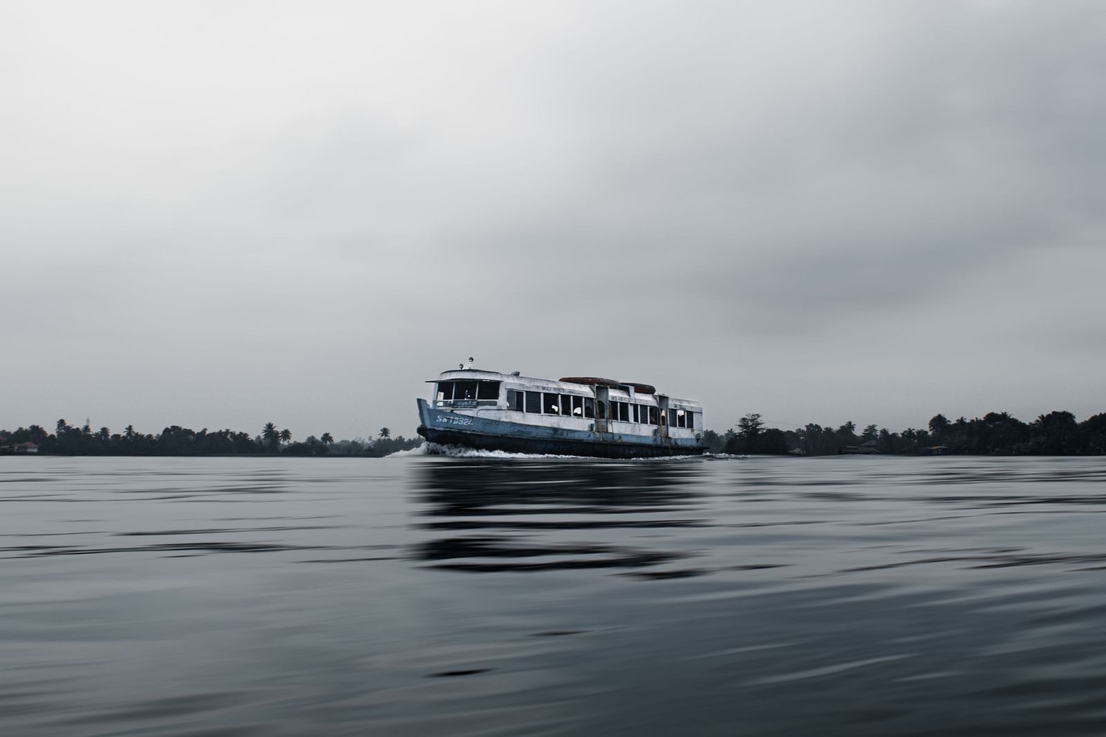 an image of Lake Vembanad in Kumarakom during the monsoon season with dark sky