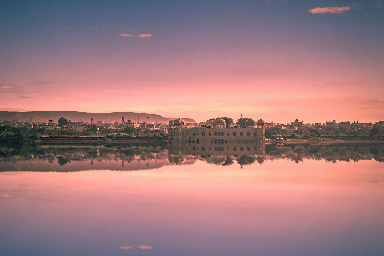 Vertical shot of a sunset sky reflected in calm water.