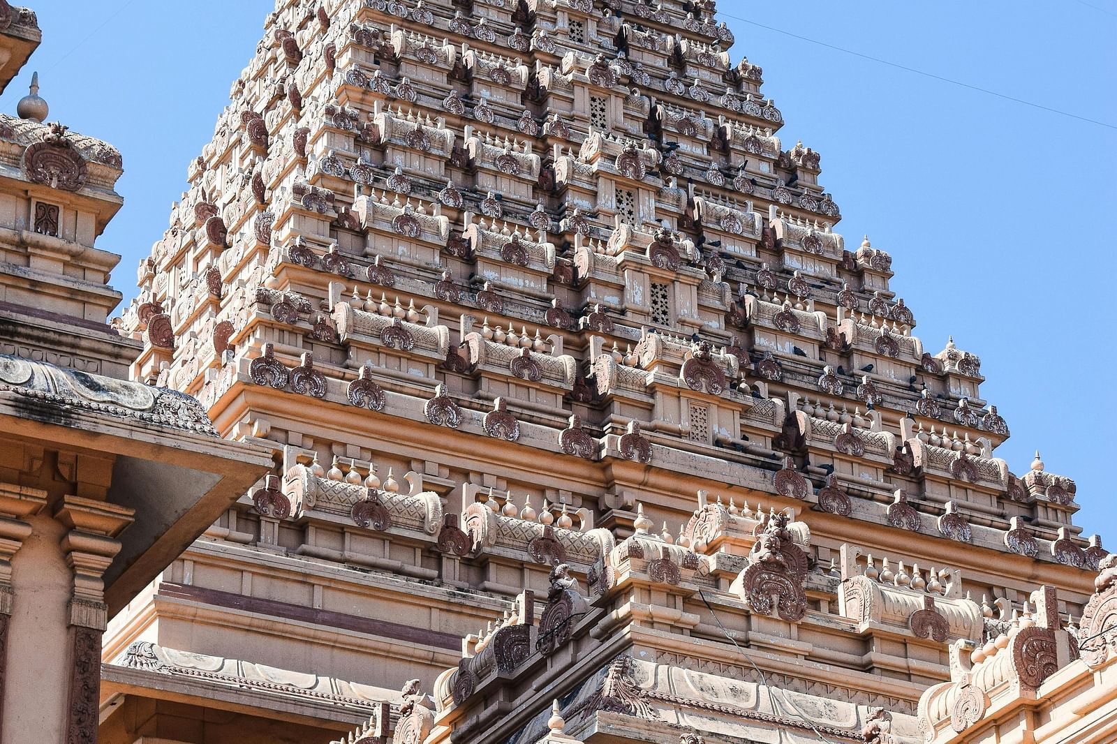 A low angle shot of a temple shikara which also has a staircase.