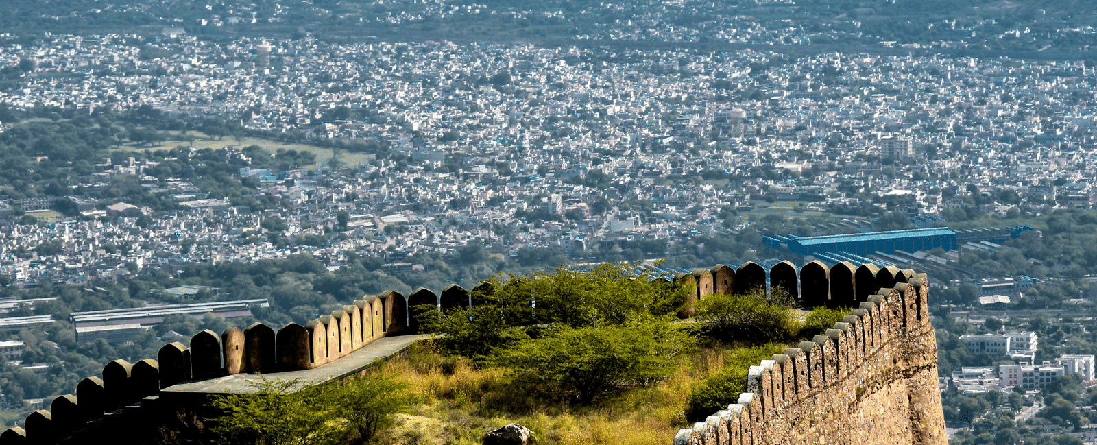 A view of the fort with greenery around & the city view & the hills at the background.