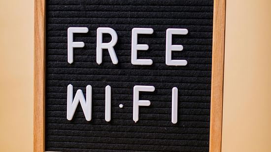 A black board stating 'Free Wi-Fi' kept on a wooden table.