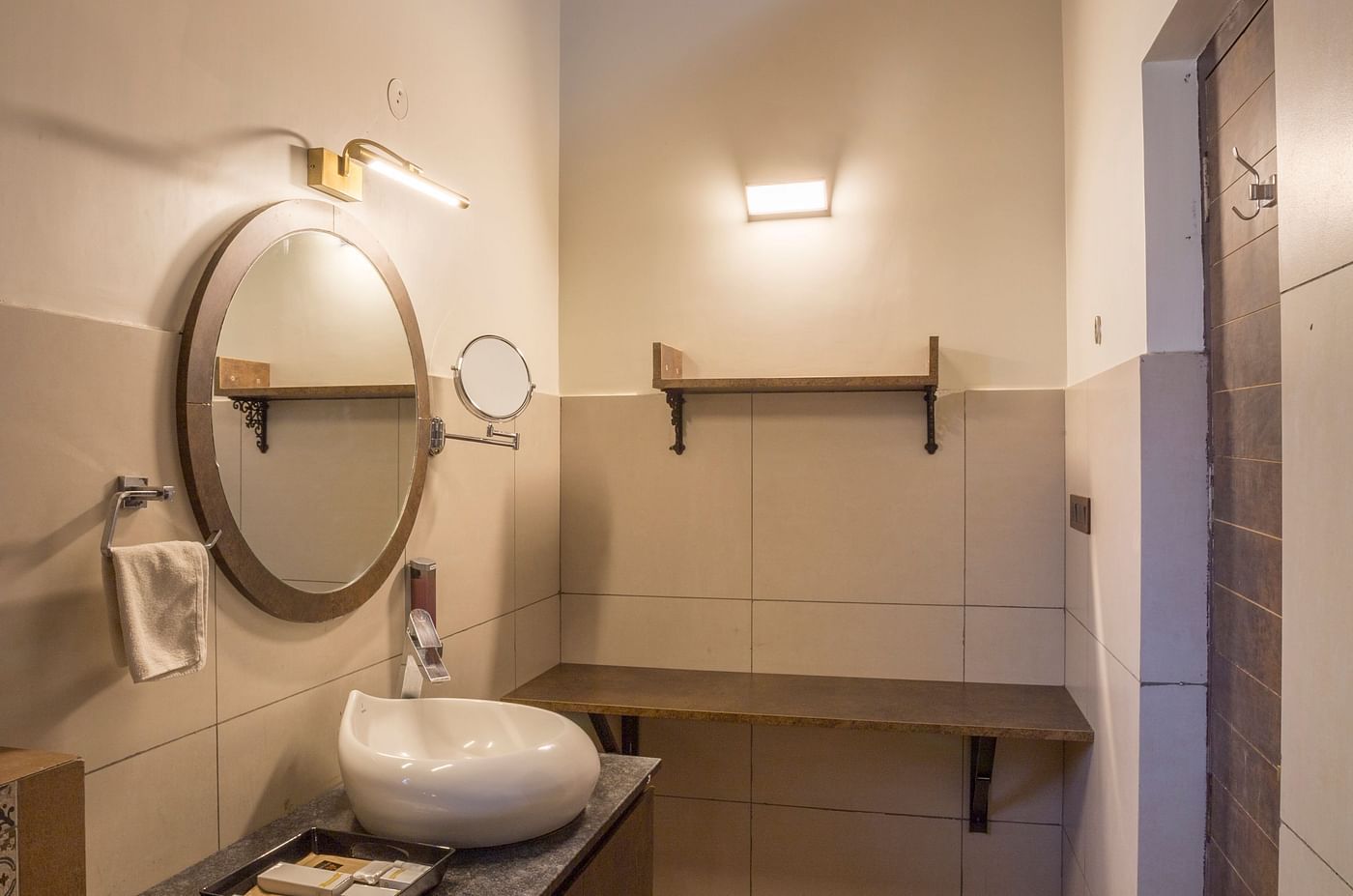 Compact bathroom with modern vanity and mirror at Nirantara Resort