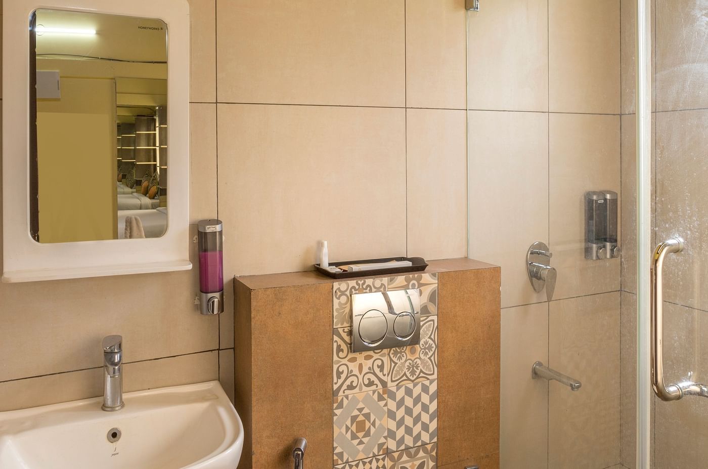 Bathroom with glass shower enclosure and wall mounted sink at Nirantara Resort