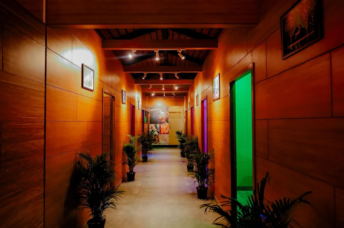 A brightly lit hallway with coluorful doors at Nirantara Resort & Spa in Bengaluru.