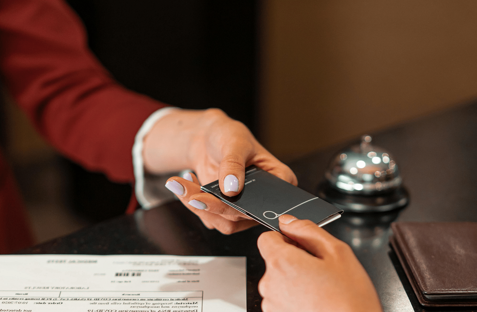 image of a person handing over a card to a customer at a reception desk