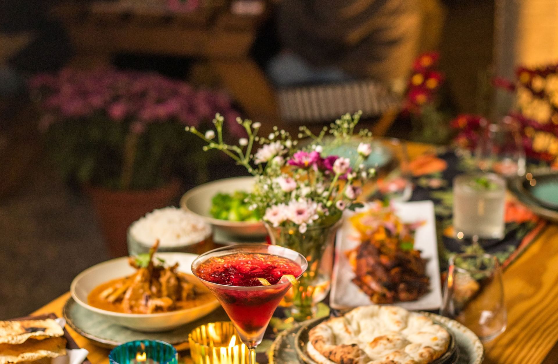 Table filled with vibrant dishes, tea set, and decorative dining elements at Karma Chalets.