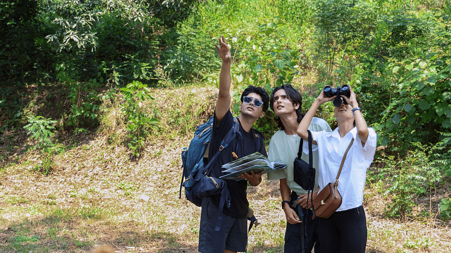 Three people pointing at the sky with a dog at The Sylvan Retreat, Dehradun.