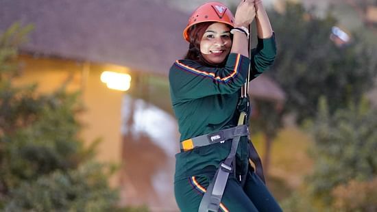 A woman zip lining at Themis Mudhouse - A Nature's Retreat Resort & Wellness
