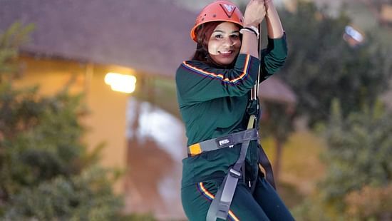 A woman zip lining at Themis Mudhouse - A Nature's Retreat Resort & Wellness