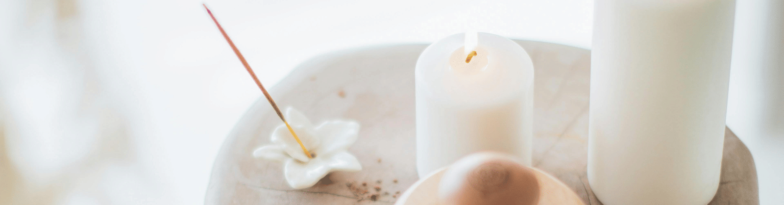 Spa setting with candles, towels, and a brush, immersed in a white background.