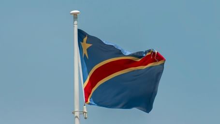 A view of the Democratic Republic of Congo's flag flying high on a pole, the best time to Visit Congo is during dry season.