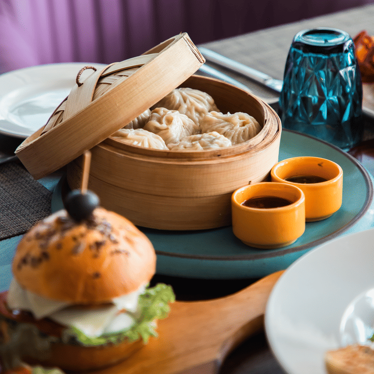 A close up shot of a table with a box of momos kept on it - Karma Lakelands.
