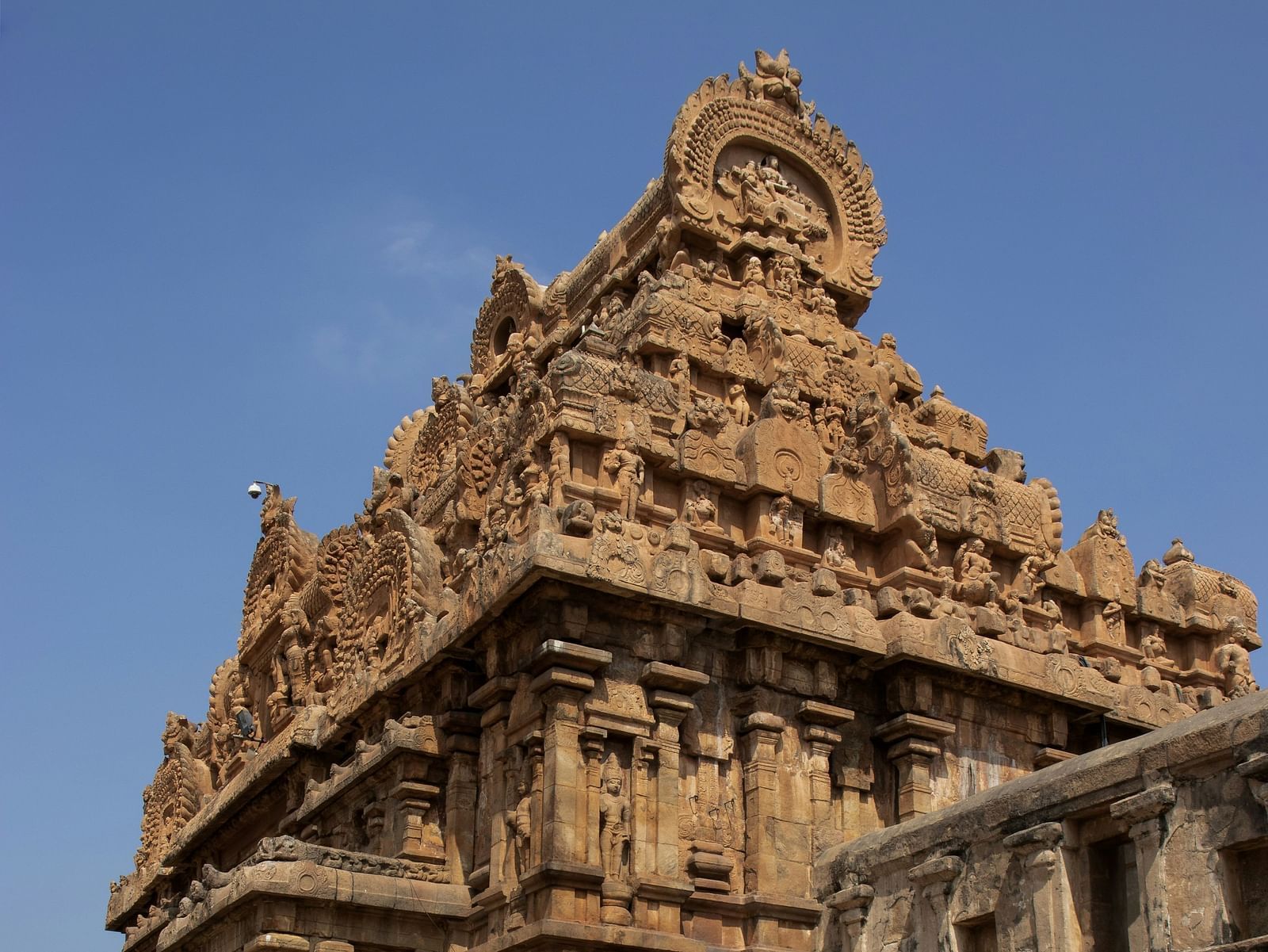 An ancient stone temple with intricate carvings under a clear sky.