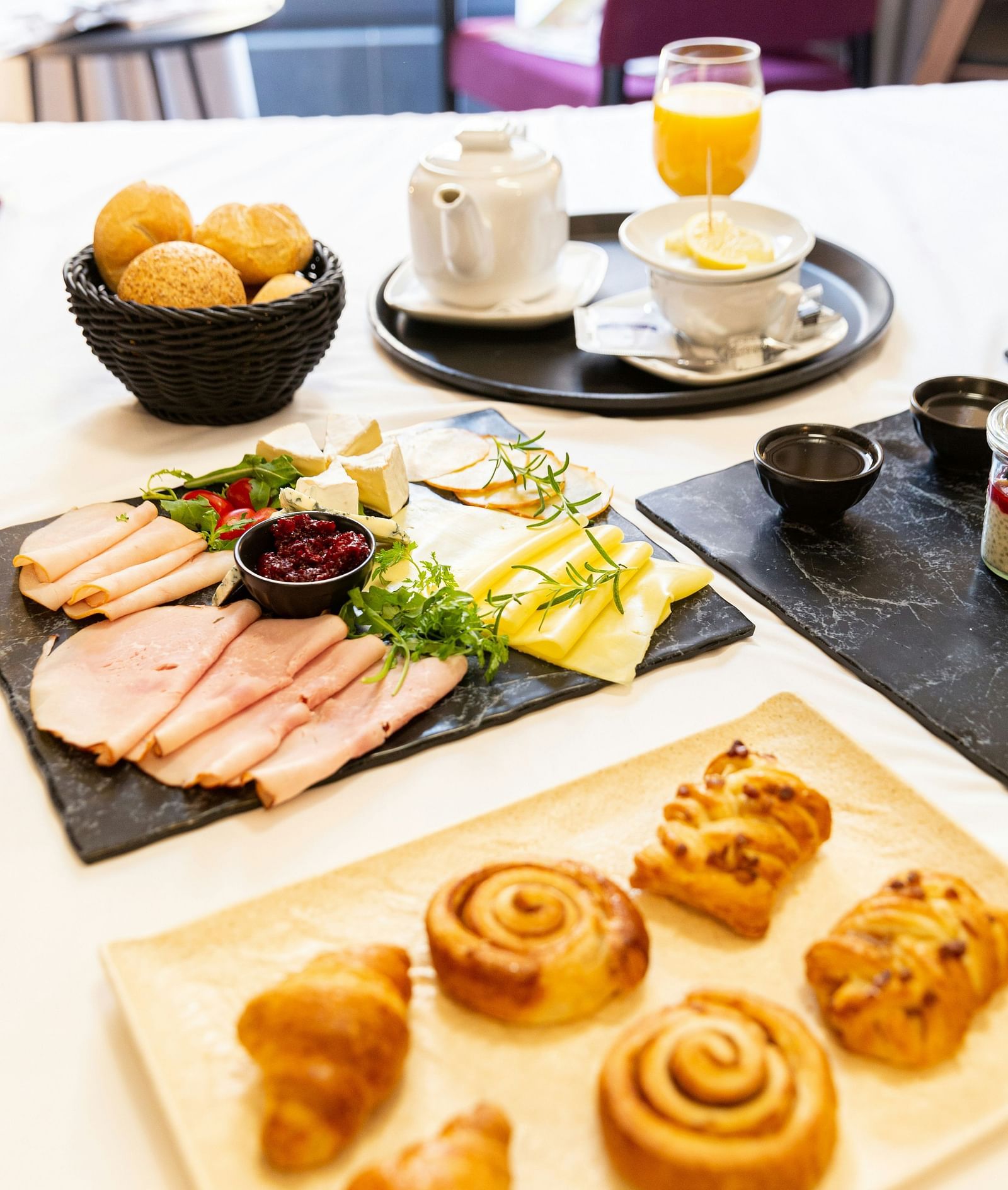 image of an assorted breakfast platter served in bed with various bakery items as well