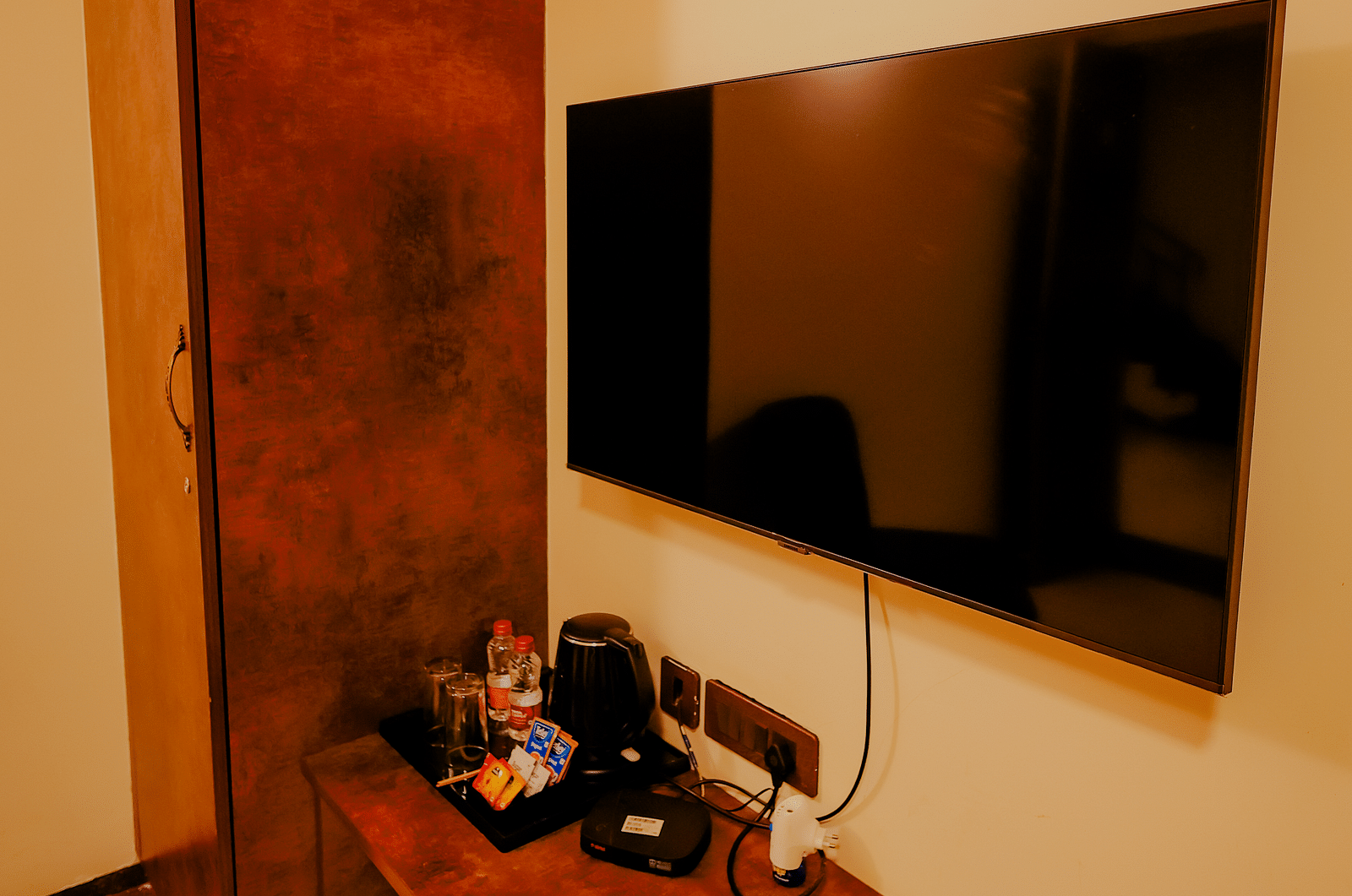 A television mounted on the wall in a room at Nirantara Resort & Spa.