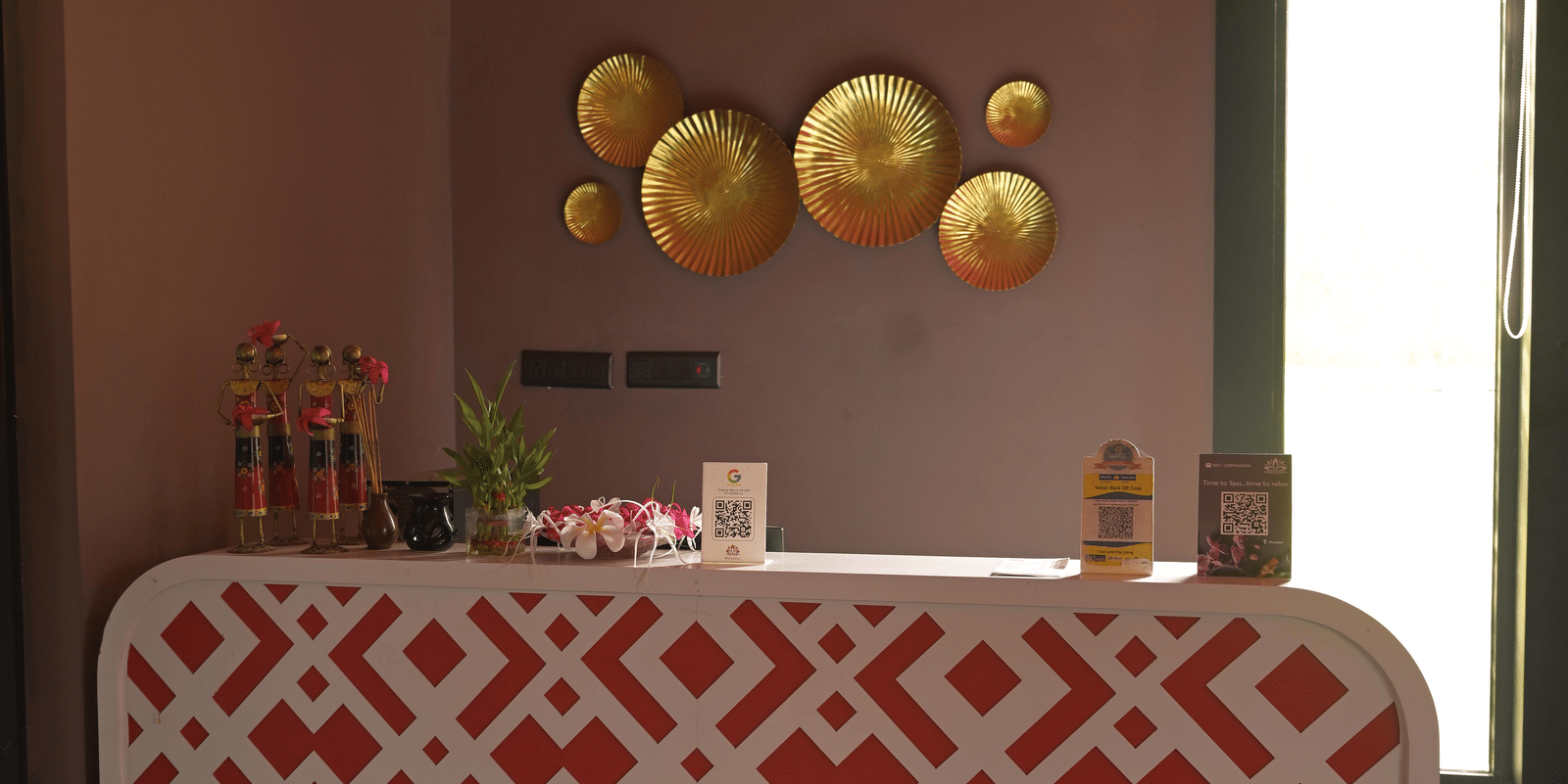 A spa reception area with patterned front desk and warm lighting at Hotel Sonar Bangla Mayapur.