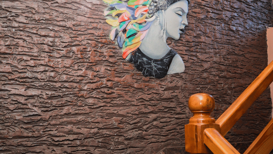The staircase at Dip Holidays featuring a stone texture wall with modern graffiti on it.