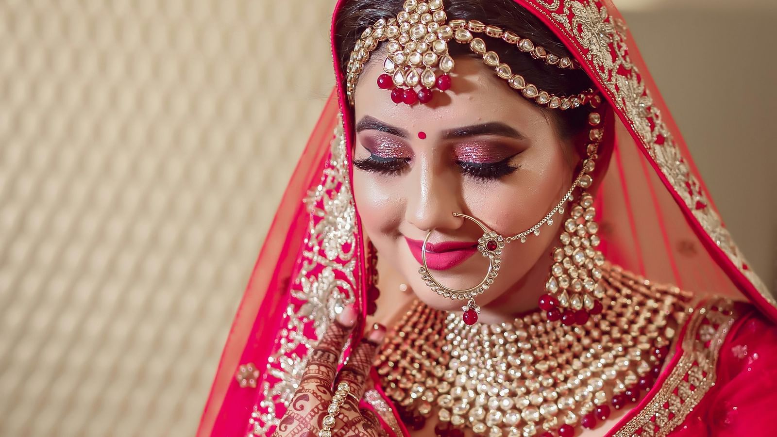 An image of a women, wearing a traditional dress with bangles and jewellery.