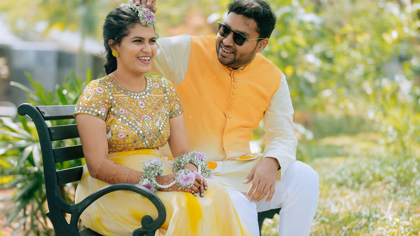 image of the bride and groom sitting together at a bench in the garden at darza resorts - coimbatore luxury resort