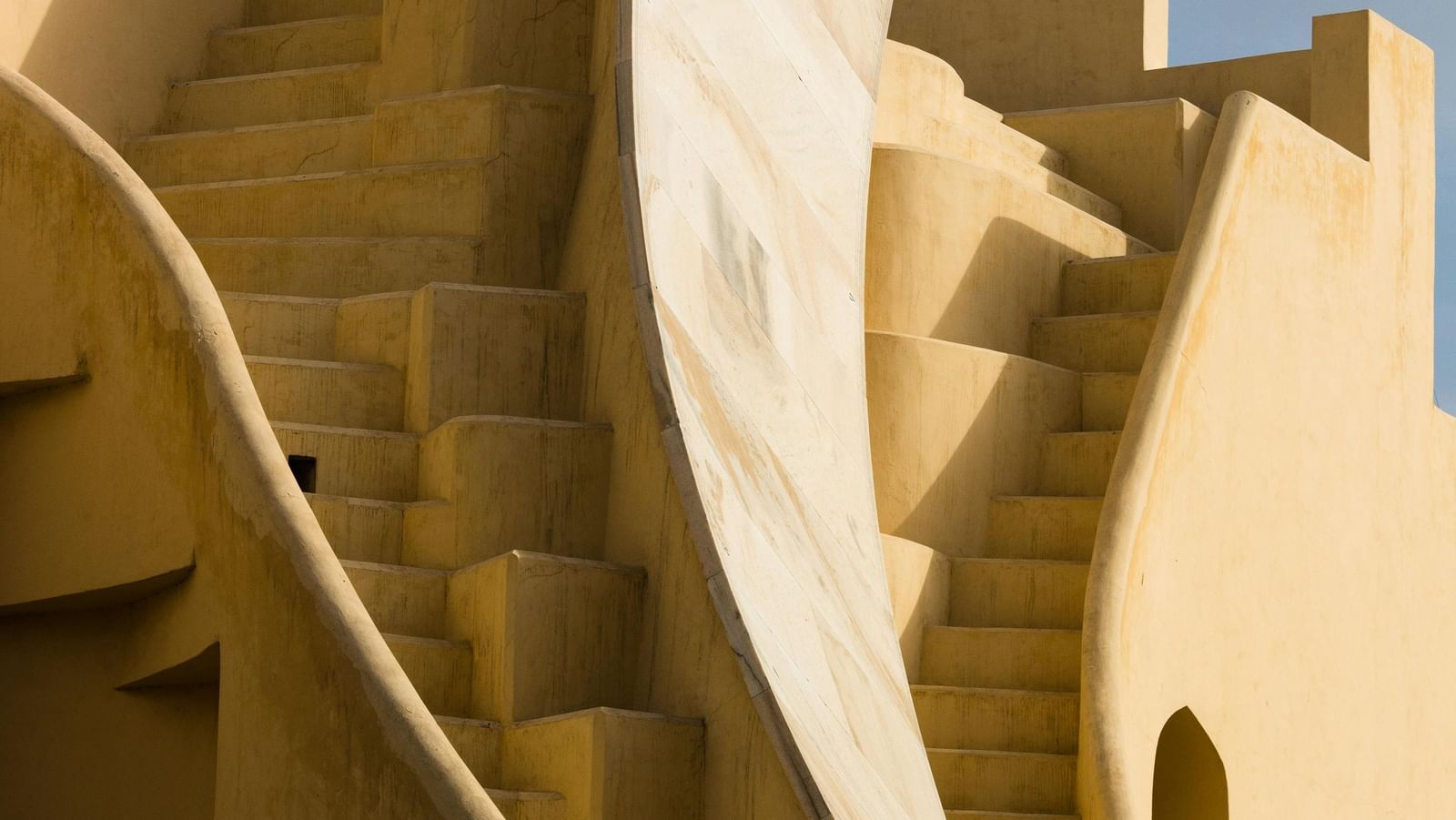 Exterior of a structure with curved staircase leading up to the terrace