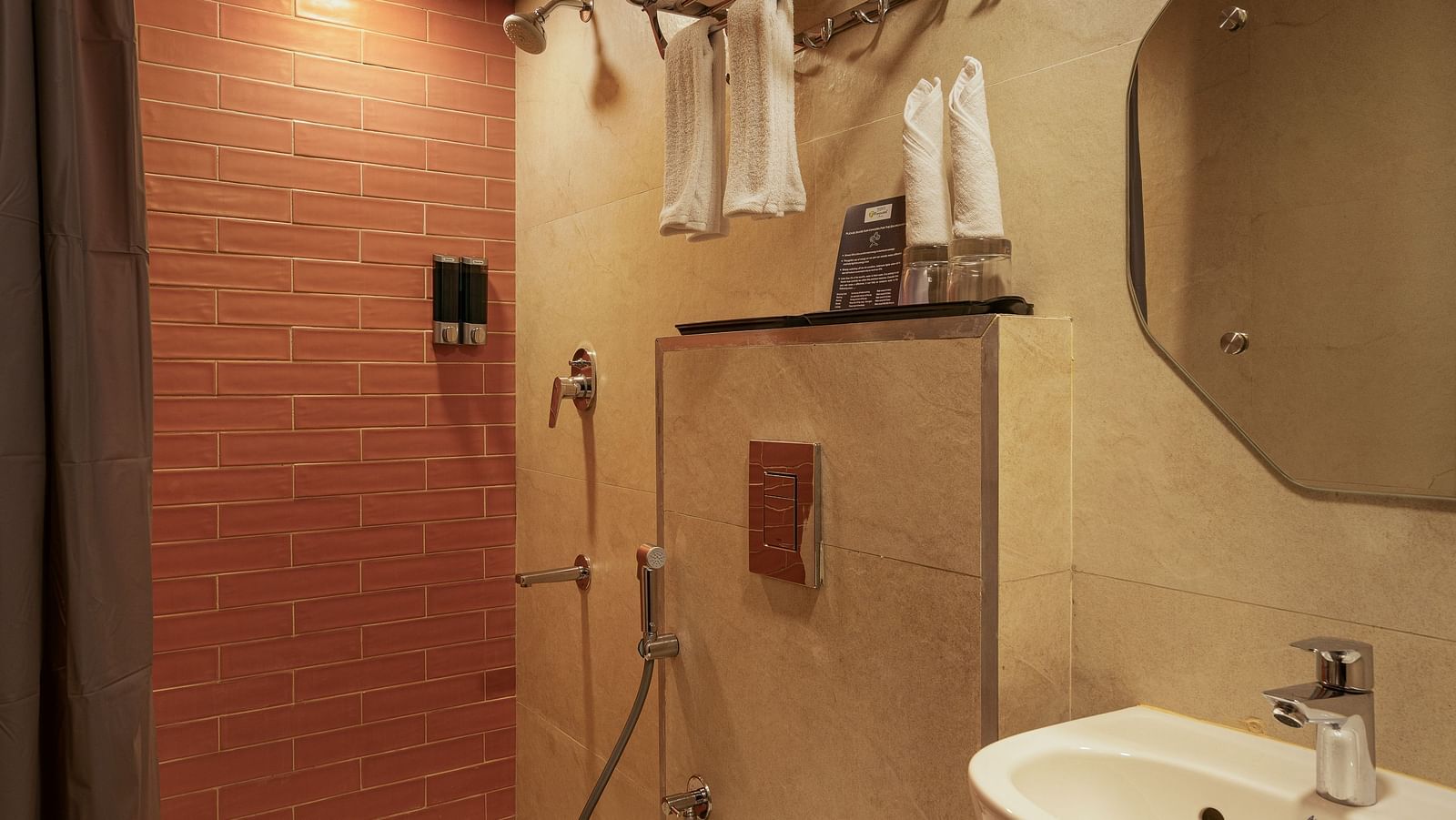 washroom with white tiles and sparkling clean washbasins and circular mirror.
