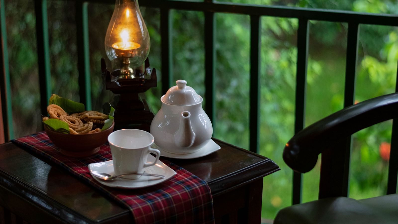 an image of a tea table placed in a balcony along with two chairs - Hoysala Village Resort, Hassan