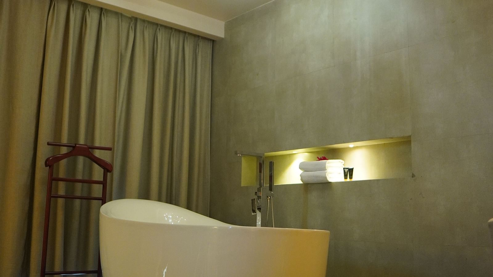 Bathtub with warm lighting and closed curtains