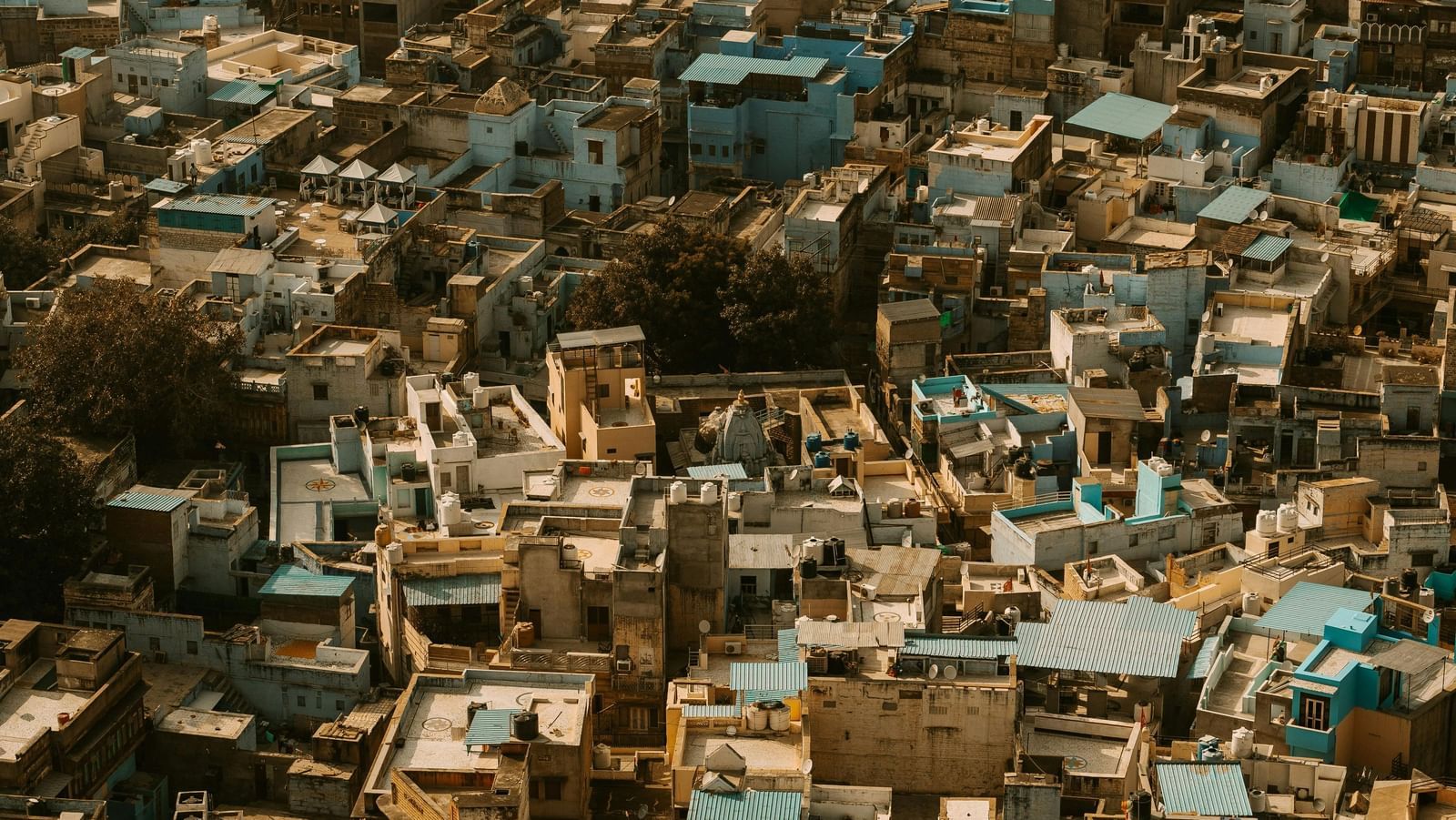 Densely packed buildings on a steep hillside, with a mix of brown and blue rooftops creating a congested, vertical cityscape.