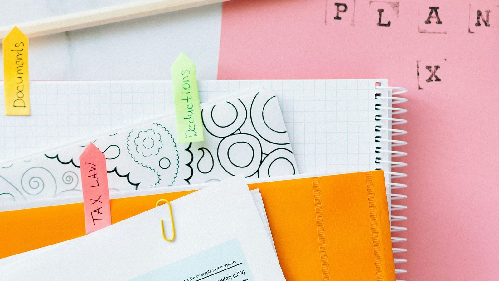 A collection of documents and papers with a percentage symbol and colourful stationery.