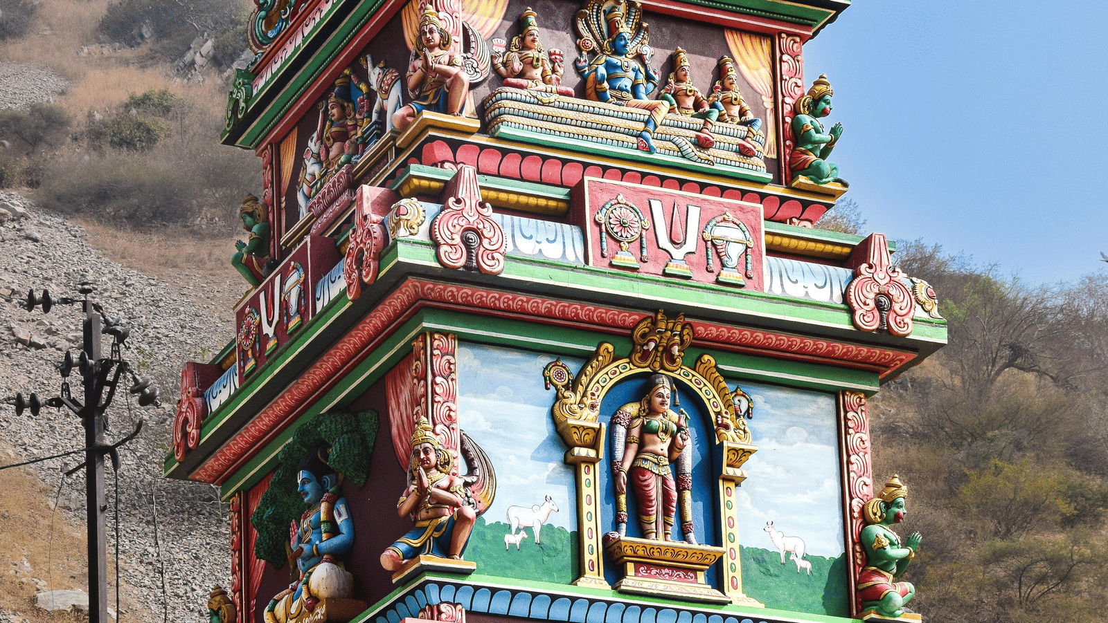 A tall, stepped, terracotta-colored masonry structure with a diagonal staircase, part of the Jantar Mantar observatory complex, is depicted under a bright, hazy sky.