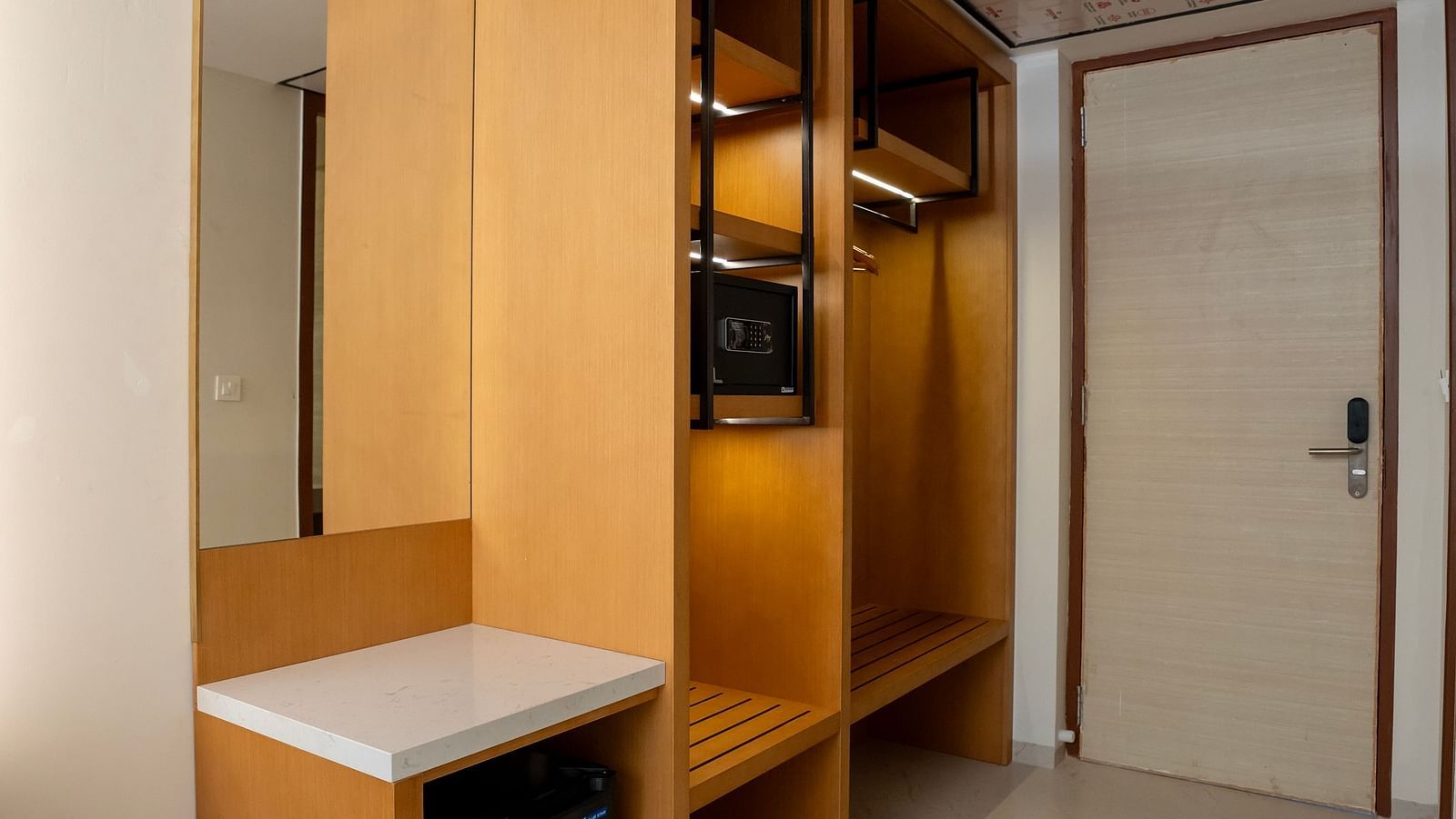 The wardrobe near the entrance corridor of the Pool View Bliss along with a mini fridge at The Shore, Trishvam.
