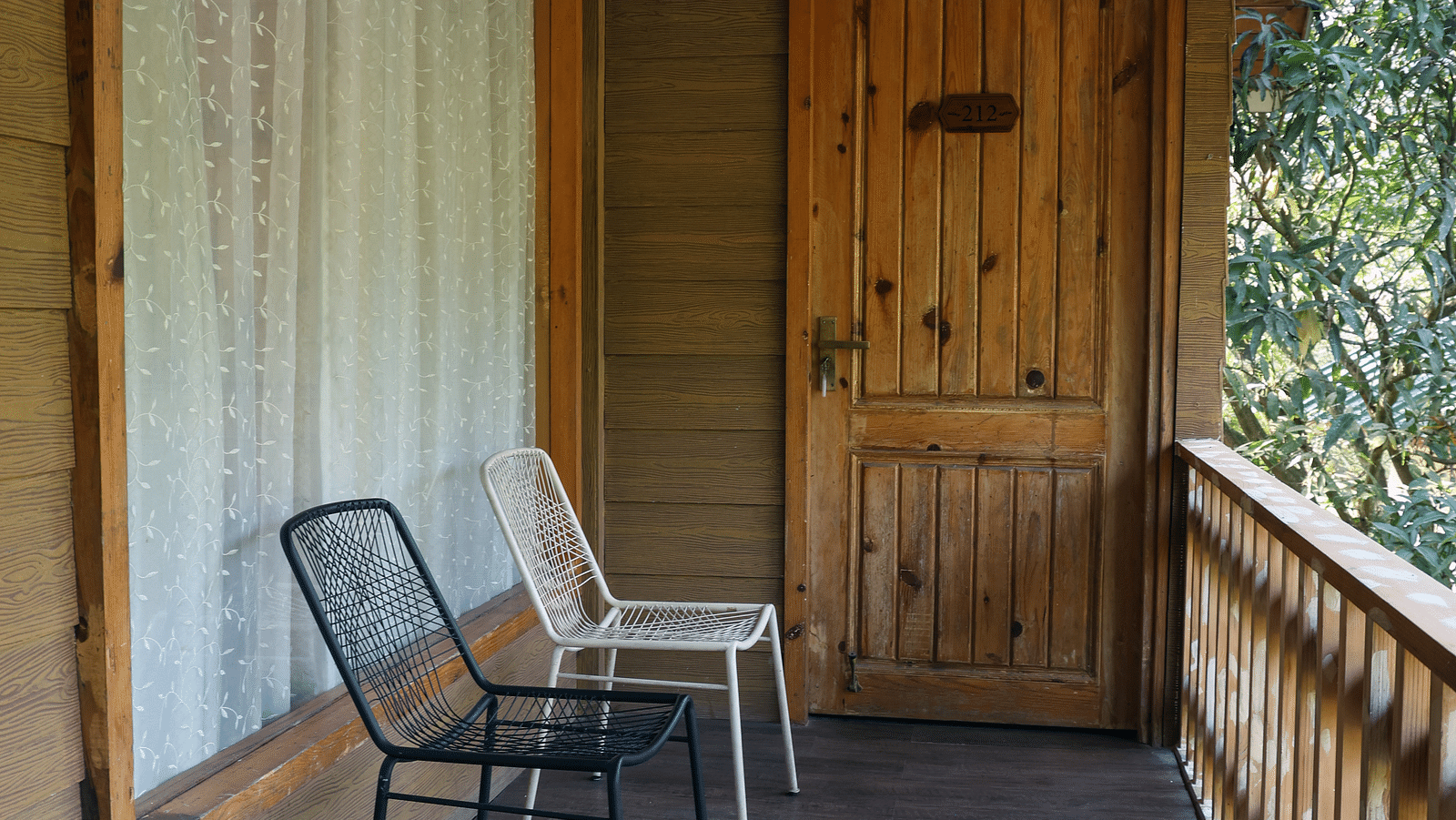 The balcony with chairs facing the view at the Pinewood Cottage at the Sylvan Retreat, Dehradun.