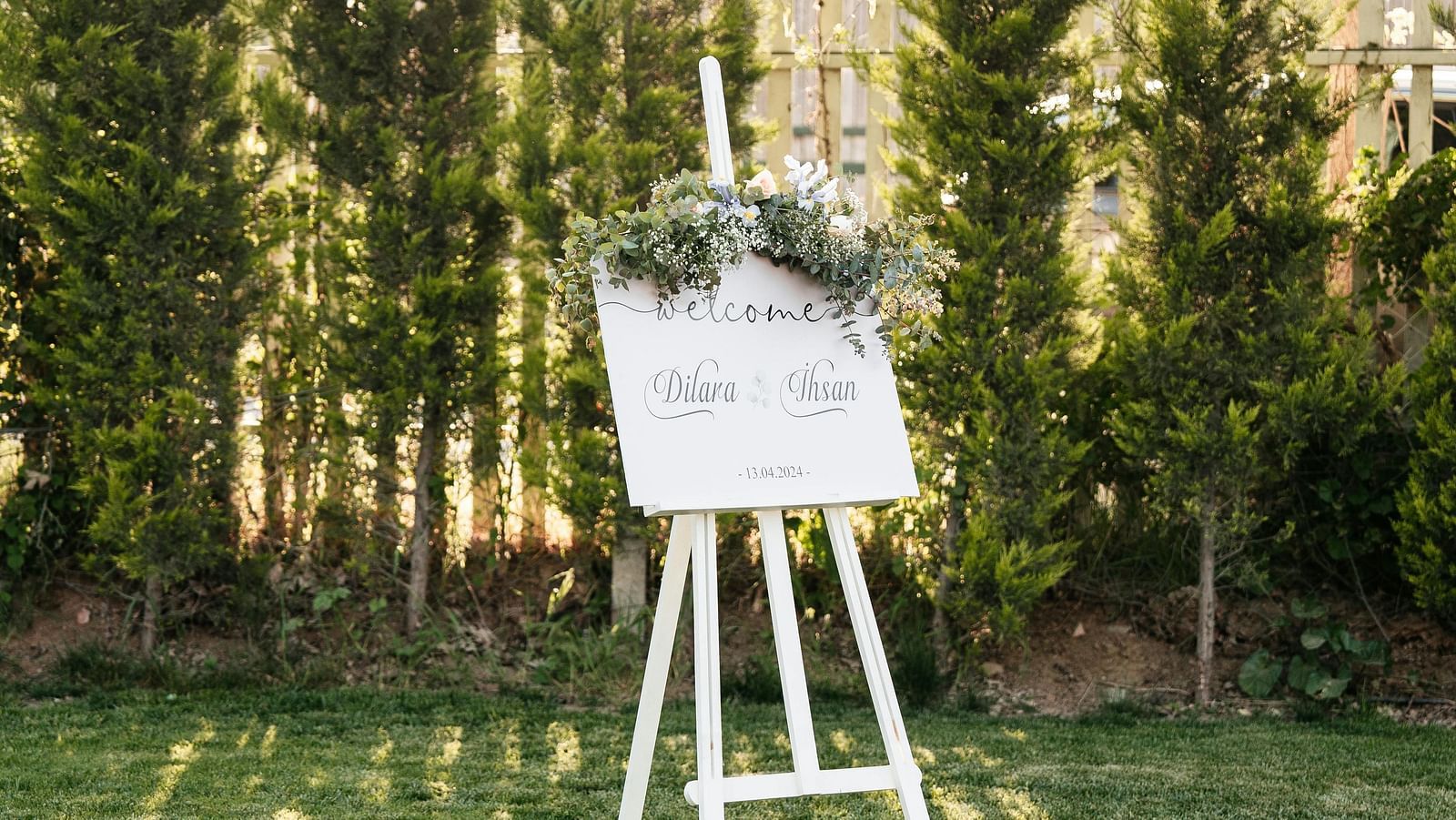 Easel setup on a green lawn surrounded by trees.