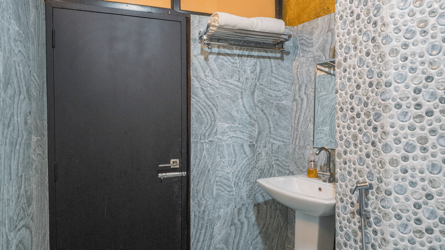 Image of a washroom with a sink next to the door at Coorg Jungle Camp Backwater Resort, Kushalnagar.