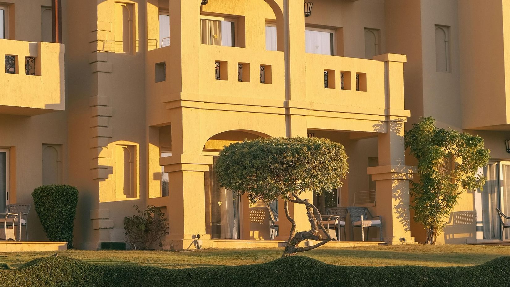 a facade image of the hotel with a swimming pool