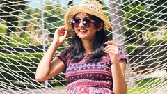 A women relaxing in a hammock outdoors, surrounded by greenery.