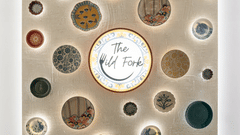 Logo of The Wild Fork restaurant along with several other artworks placed on the wall at La Marvella, Bengaluru